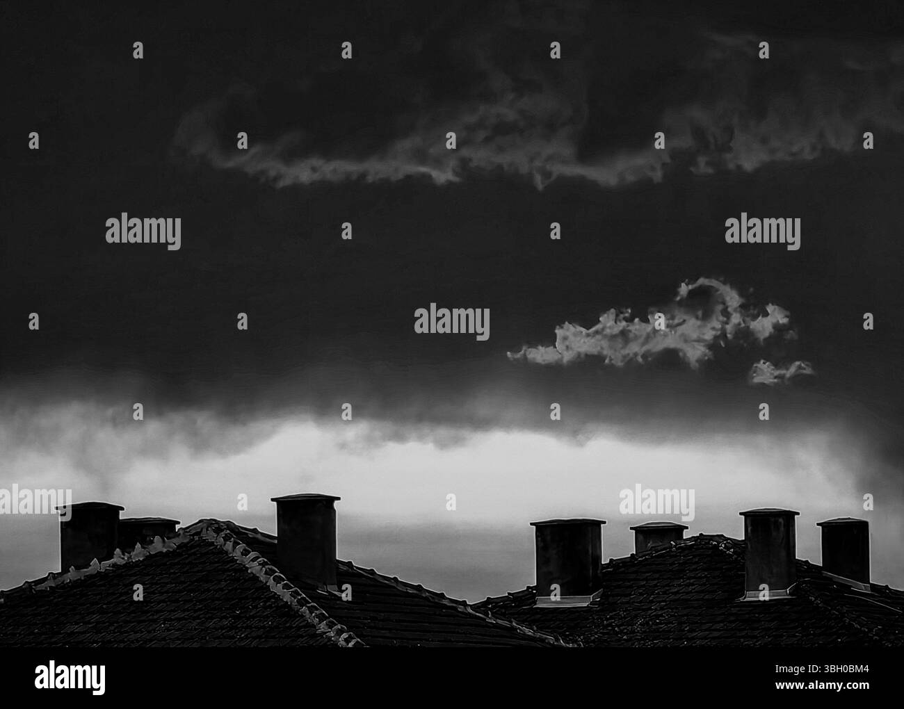 Ciel enflammé sur les toits. Teintes monochromes Banque D'Images