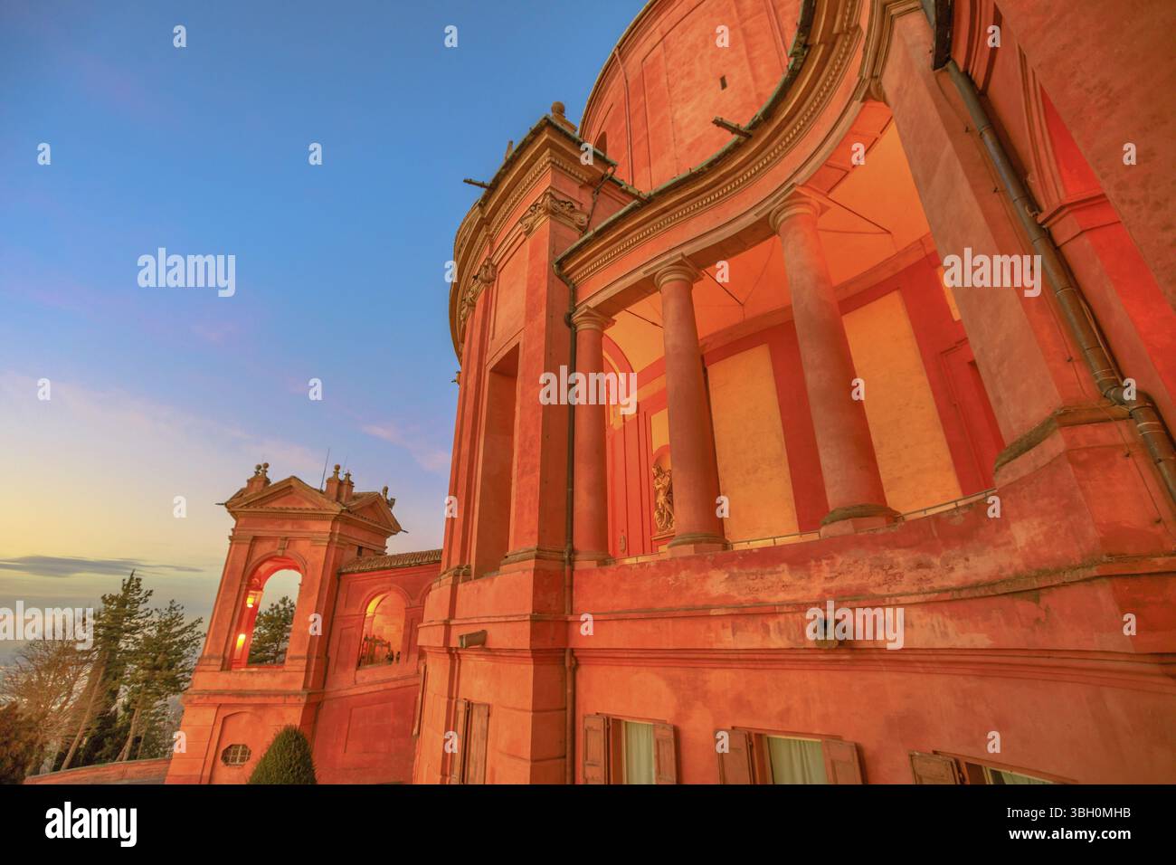 Vue latérale de la façade du Sanctuaire de Madonna di San Luca et arcades de son long portique avec lumière de coucher de soleil. L'église de la Bienheureuse Vierge de San Luca Banque D'Images