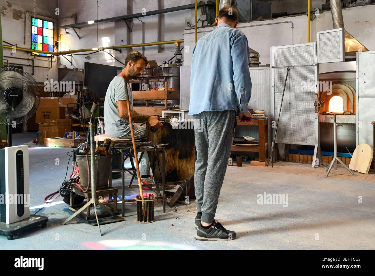 Deux maîtres verriers créant un vase dans une usine de verre de Murano, Venise, Vénétie, Italie Banque D'Images