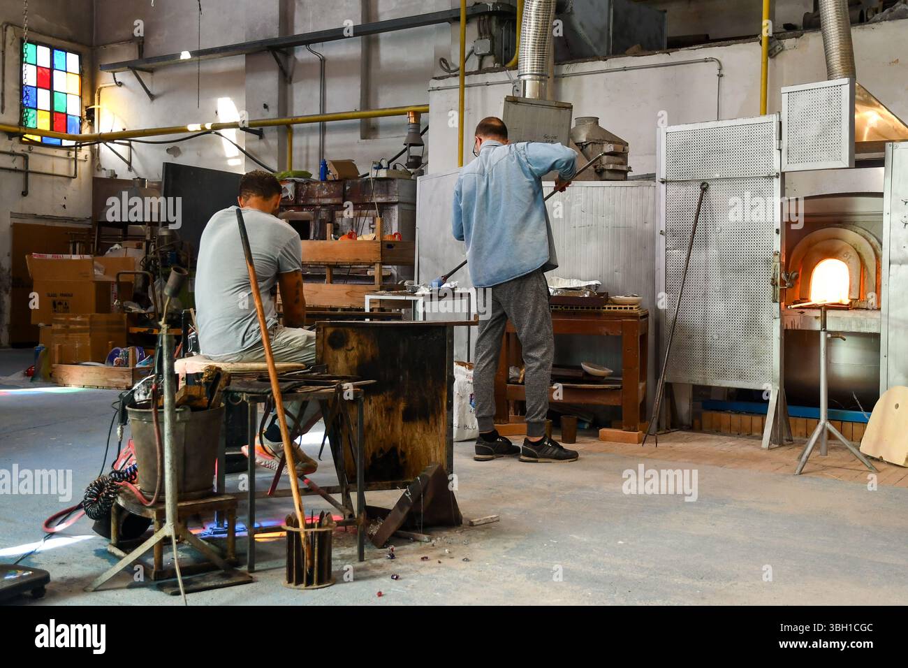 Deux maîtres verriers créant un vase dans une usine de verre de Murano, Venise, Vénétie, Italie Banque D'Images