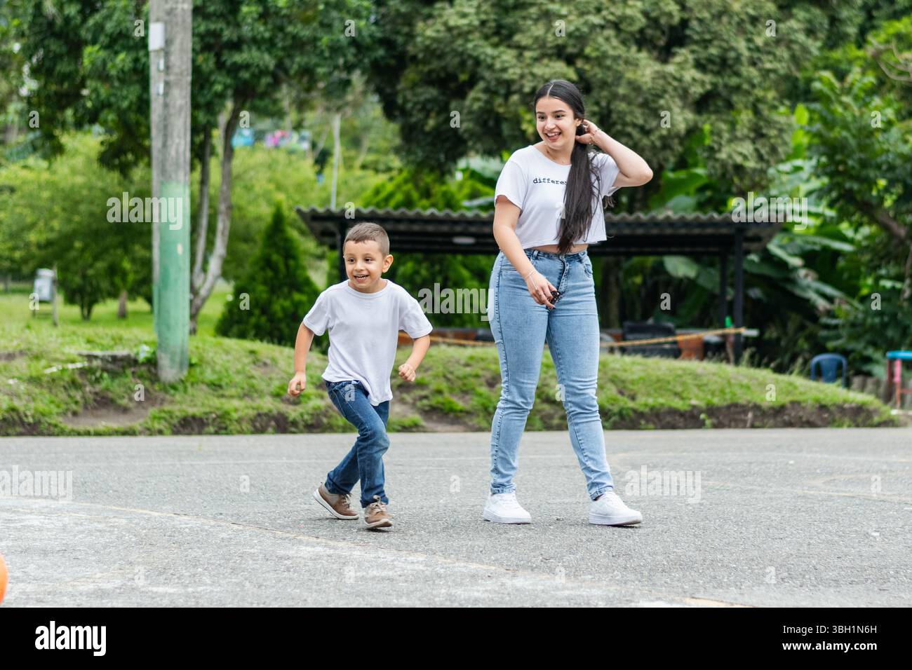 Garçon avec sa mère jouant joyeusement et souriant dans un parc naturel. Banque D'Images