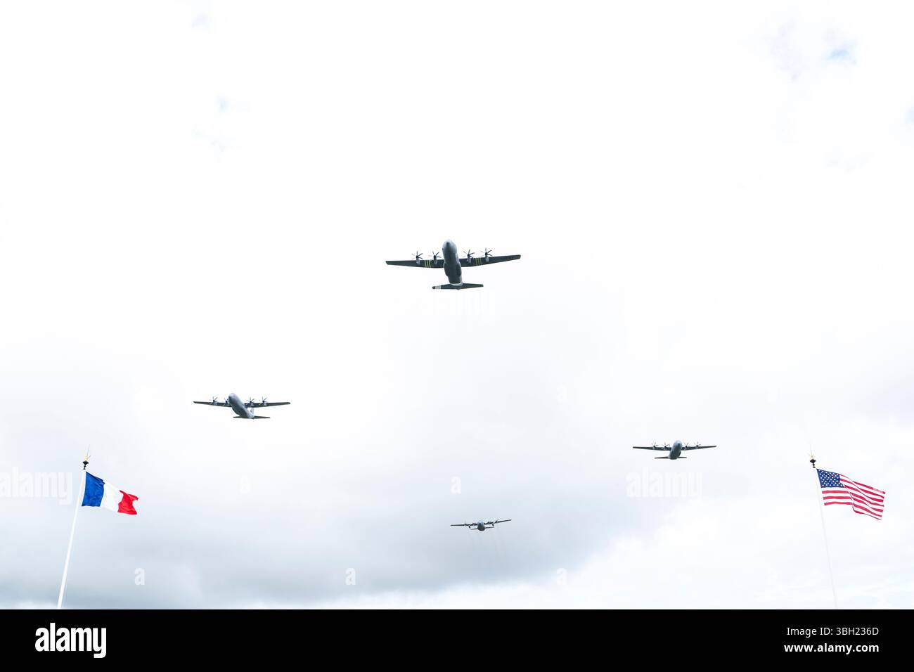 Des avions de la seconde Guerre mondiale volent au-dessus de leur tête lors de la cérémonie du cimetière américain de Normandie, Colleville-sur-mer, France, le 6 juin 2025. (Photo du DOD par le premier maître de 1re classe Alexander Kubitza de l'US Navy) Banque D'Images