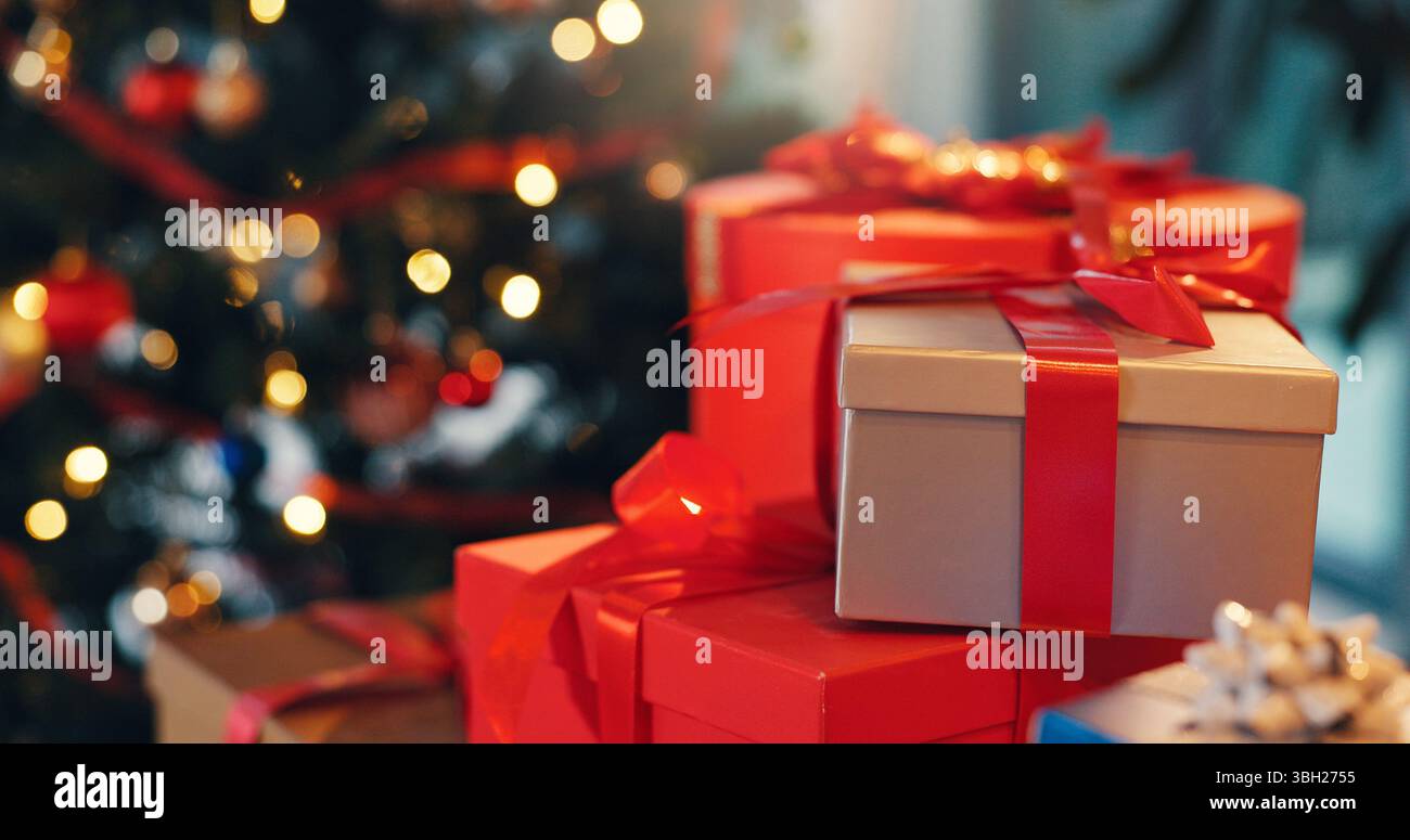 Noël, boîtes et cadeaux à la maison pour célébration, fête ou événement avec tradition festive. Décorations, paquets et cadeaux en carton avec ruban par Banque D'Images