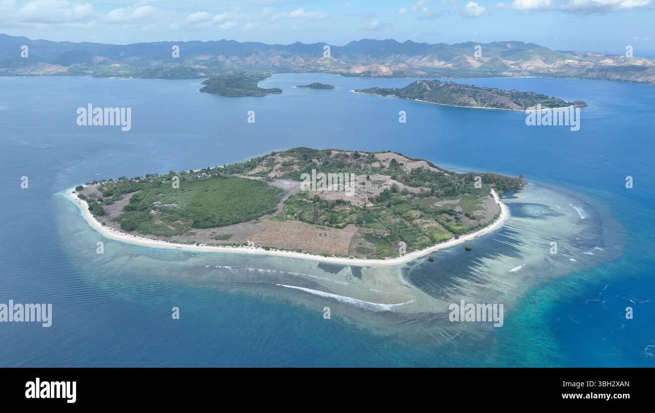 Gili Layar d'en haut montre sa beauté intacte, avec des eaux claires, des coraux peu profonds et la toile de fond pittoresque des îles Lombok sous un ciel lumineux. Banque D'Images