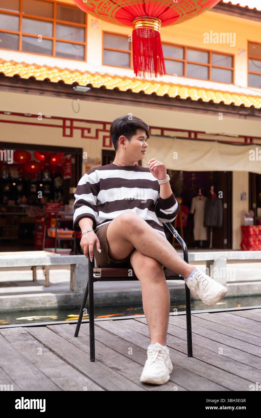 Jeune homme gay asiatique mignon dans le marché de style chinois pendant la journée Banque D'Images