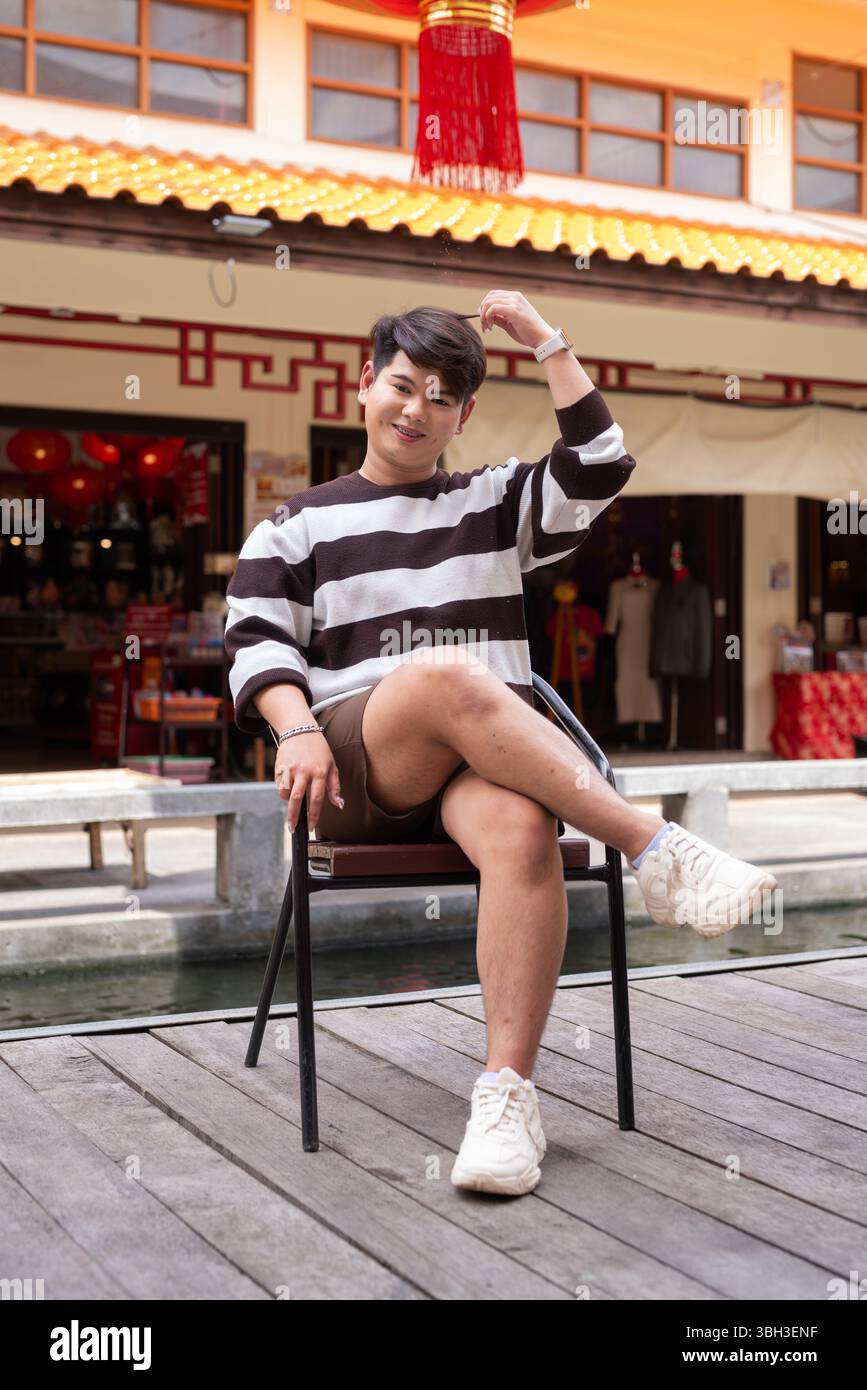 Jeune homme gay asiatique mignon dans le marché de style chinois pendant la journée Banque D'Images