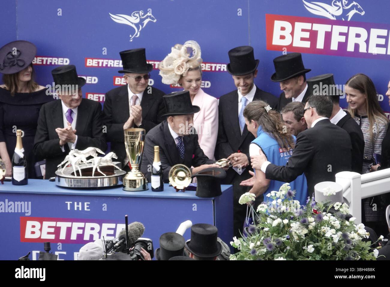 Epsom Downs Racecourse, Epsom, Surrey, Royaume-Uni. 7 juin 2025. La présentation par Fred a fait propriétaire du groupe de Paris Betfred aux gagnants et aux propriétaires - et ici à la tête de la dame stable, après Lambourn a pris les 18 autres chevaux à part avec une grande victoire - le 'Betfred Derby' (en l'honneur de son Altesse Aga Khan IV ) - course du Groupe 1. Crédit : Motofoto/Alamy Live News Banque D'Images