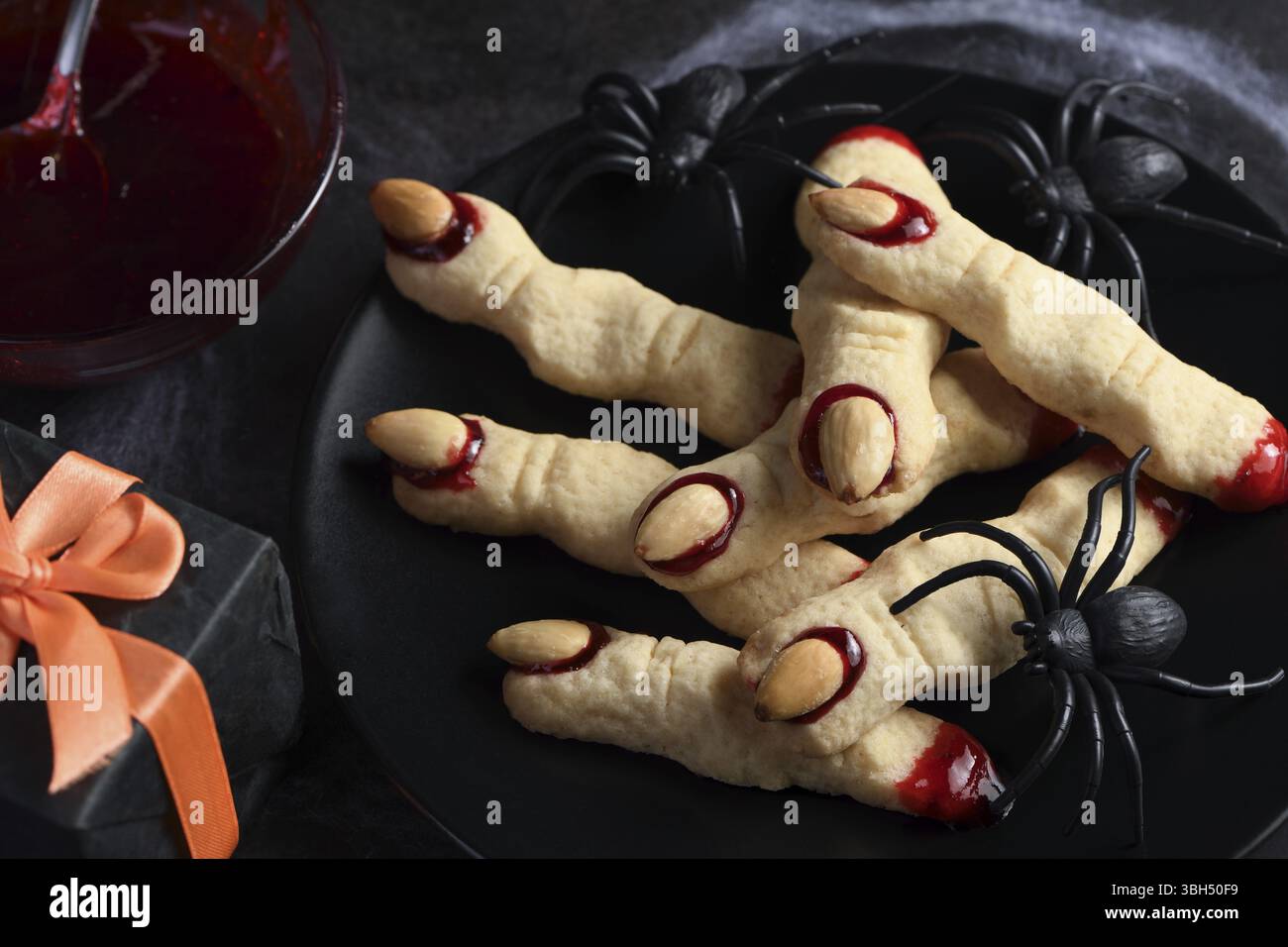 Doigts de sorcière effrayant et effrayant à base de biscuits au sucre avec confiture de framboises et amandes à Halloween. Friandises ou friandises. Classic cookie Witch Fingers prend le dessus Banque D'Images