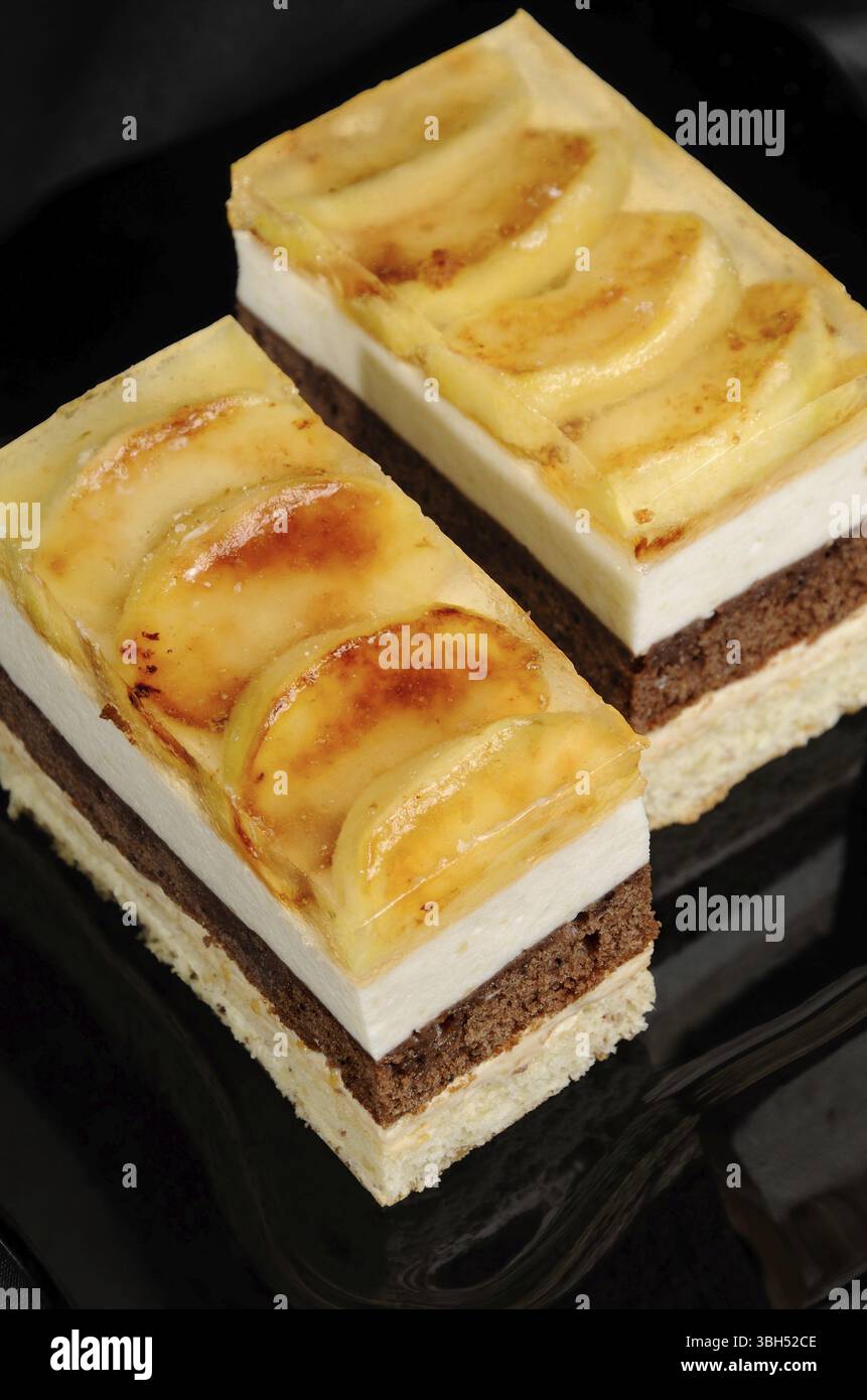 Empilées de gâteau au caramel, chocolat, mousse de pomme et amande biscuit avec une couche de gelée de pommes caramélisées tranches Banque D'Images