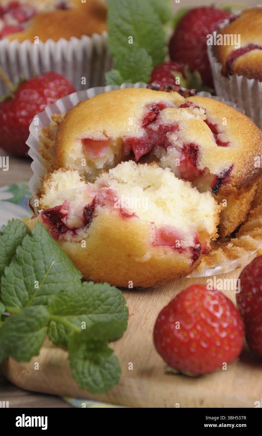 Muffin pause avec des fraises sur une table entre les fruits et la menthe Banque D'Images