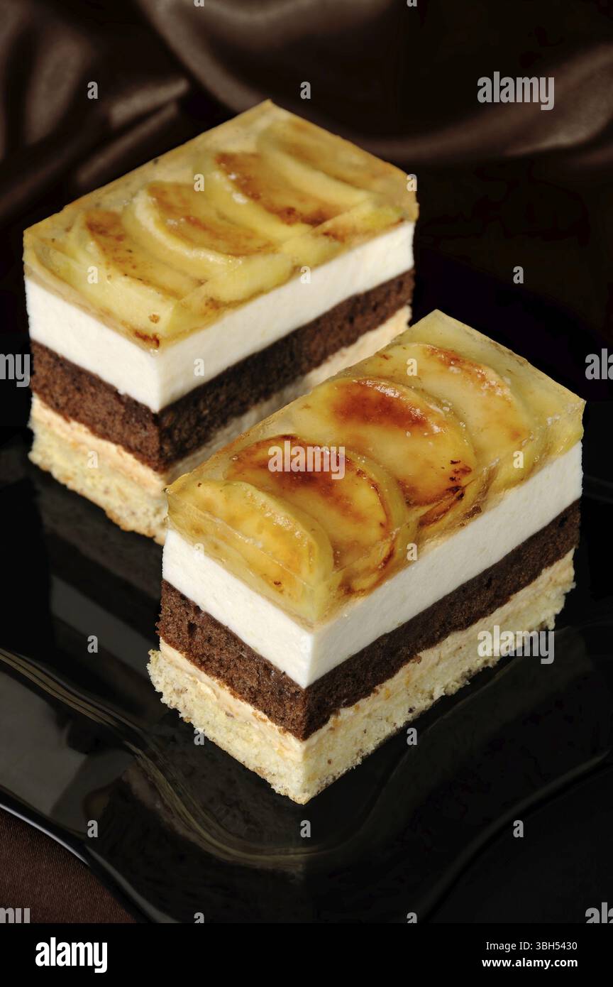 Empilées de gâteau au caramel, chocolat, mousse de pomme et amande biscuit avec une couche de gelée de pommes caramélisées tranches Banque D'Images