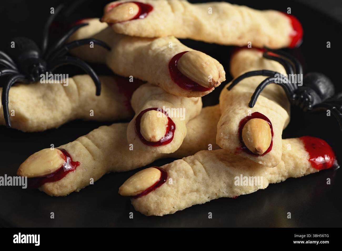 Doigts de sorcière effrayant et effrayant à base de biscuits au sucre avec confiture de framboises et amandes à Halloween. Friandises ou friandises. Classic cookie Witch Fingers prend le dessus Banque D'Images