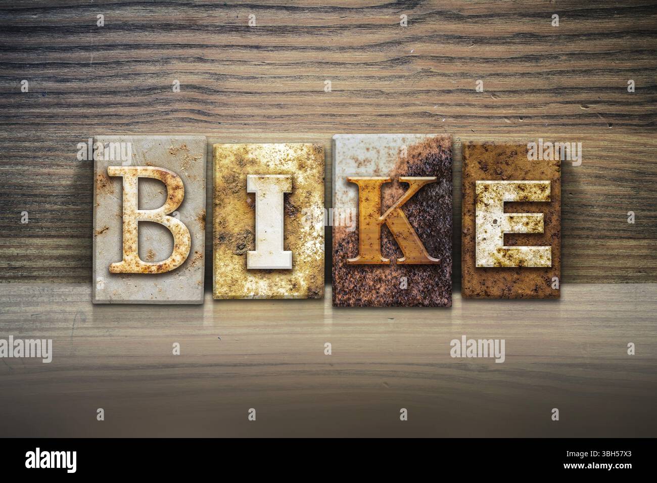 Le mot BIKE écrit en typographie en métal rouillé, assis sur un fond de rebord en bois Banque D'Images