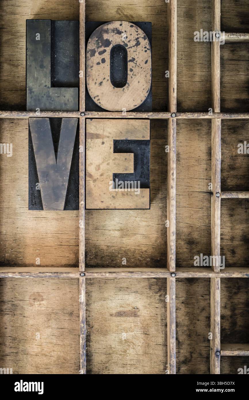 Le mot LOVE écrit en typographie vintage en bois dans un tiroir diviseur en bois Banque D'Images