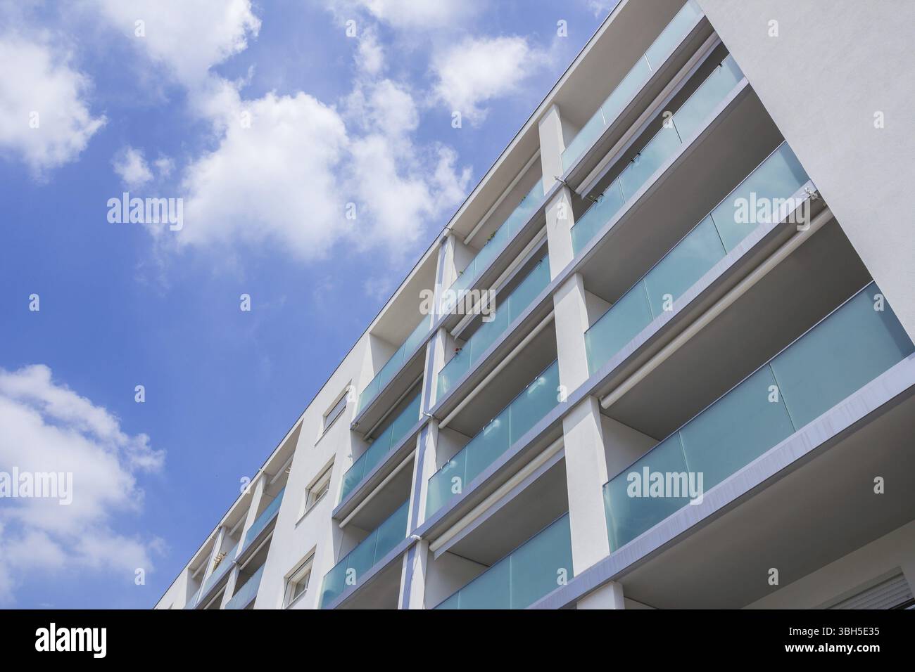 Appartement moderne construit sur une journée ensoleillée avec un ciel bleu. Façade d'un immeuble neuf Banque D'Images
