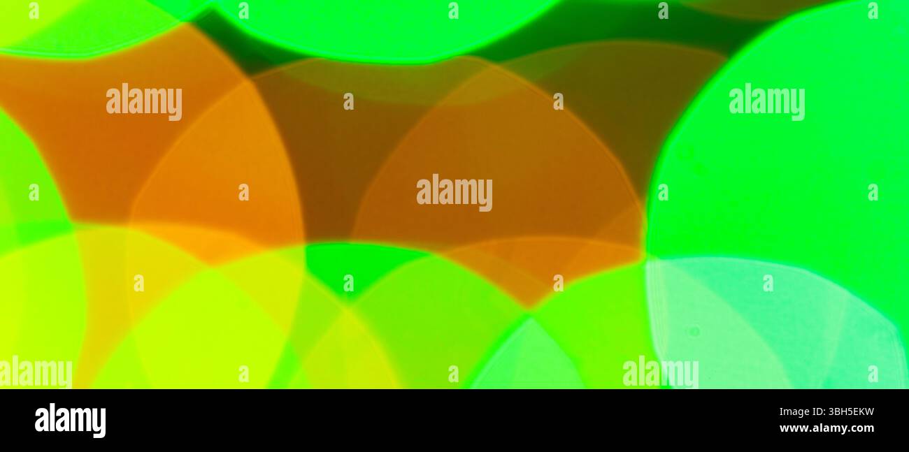 Fond bokeh abstrait éclatant avec effet de lumières éclatantes floues vert orange et jaune superposées Banque D'Images