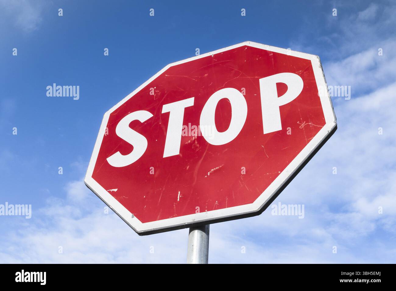Stop panneau routier sur un fond de ciel bleu avec des nuages blancs Banque D'Images