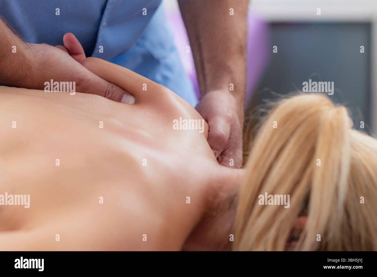 Massage des tissus profonds par physiothérapeute sur une épaule des patients pour soulager la tension musculaire et améliorer la mobilité. Banque D'Images