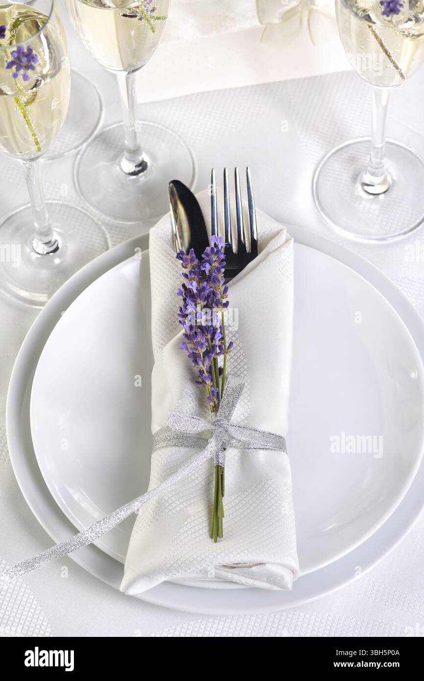 Table à manger de style provençal, avec champagne Lavender, serviette pliée avec couverts, décorée de lavande fraîche. Détail du dîner de mariage. Mer Banque D'Images