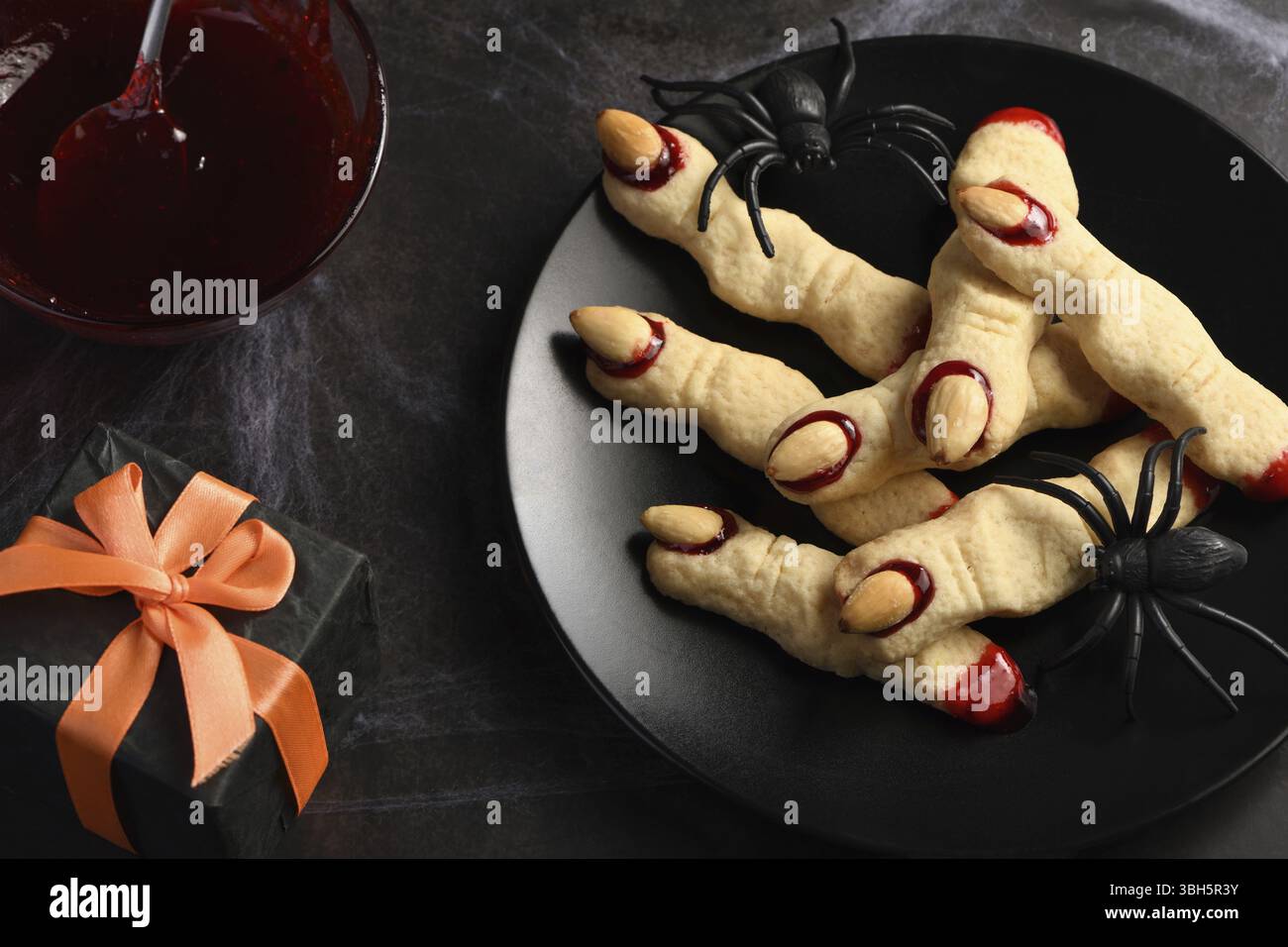 Doigts de sorcière effrayant et effrayant à base de biscuits au sucre avec confiture de framboises et amandes à Halloween. Friandises ou friandises. Classic cookie Witch Fingers prend le dessus Banque D'Images