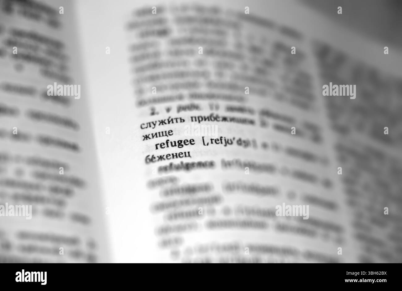 Texte de mot de définition de réfugié dans la page de dictionnaire. Faible profondeur de champ. Langue russe traduire . Image en noir et blanc Banque D'Images