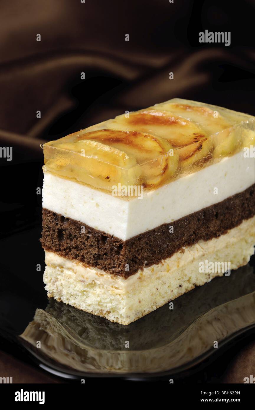 Empilées de gâteau au caramel, chocolat, mousse de pomme et amande biscuit avec une couche de gelée de pommes caramélisées tranches Banque D'Images