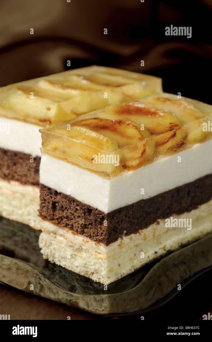 Empilées de gâteau au caramel, chocolat, mousse de pomme et amande biscuit avec une couche de gelée de pommes caramélisées tranches Banque D'Images