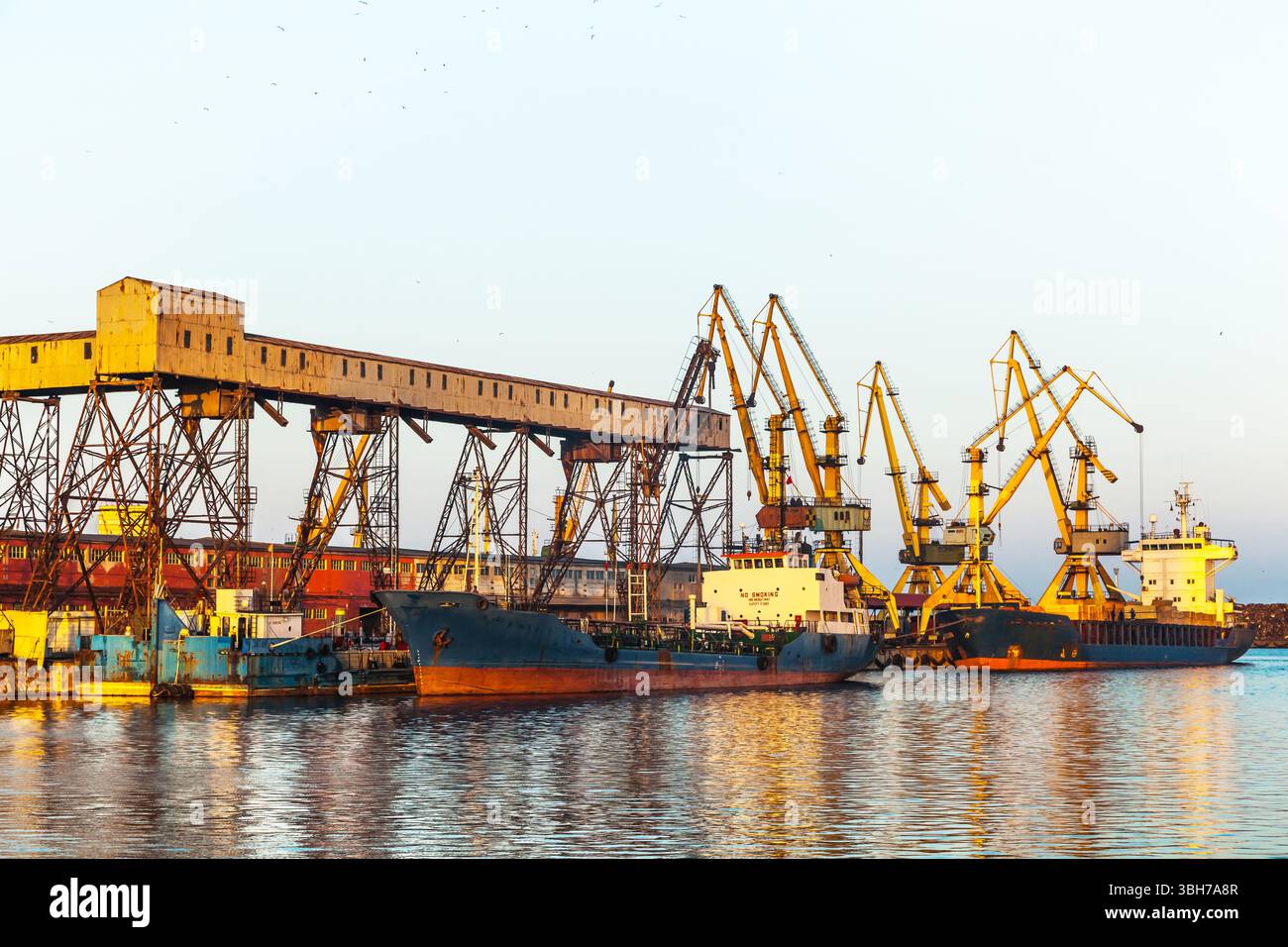 Un cargo sec et un navire-citerne sont debout dans le port de Constanta Roumanie et sont en cours de chargement. Banque D'Images