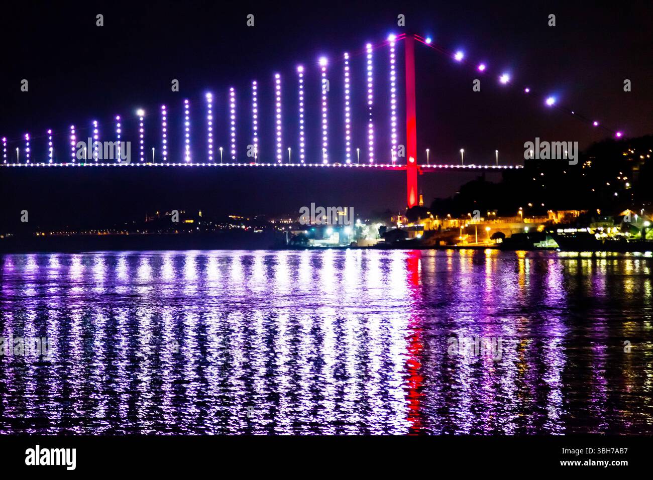 Pont lumineux de nuit avec des reflets d'eau, détroit du Bosphore, Istanbul Turquie. Banque D'Images