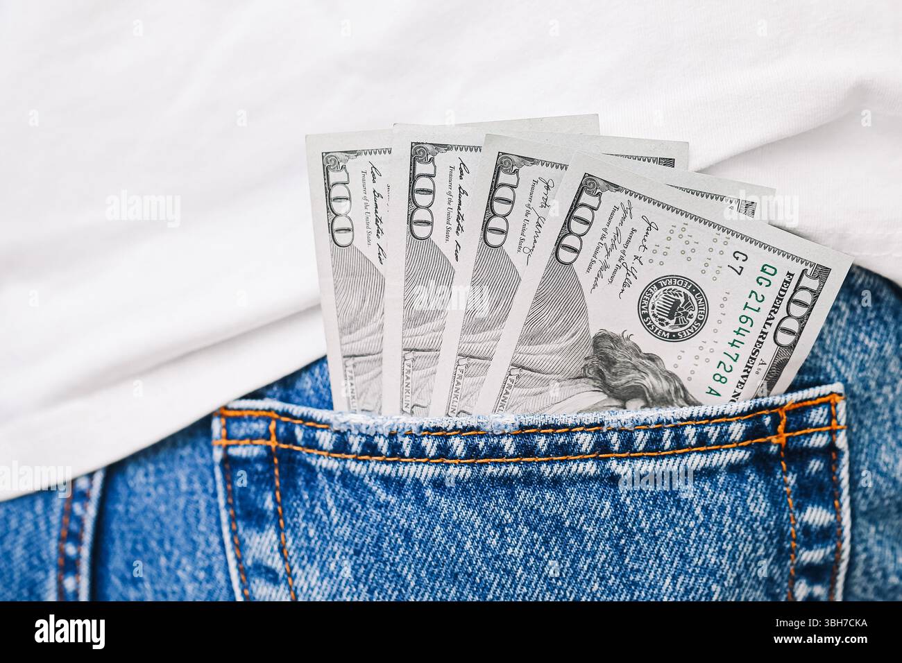 De l'argent dans la poche. Des billets de cent dollars sortent des jeans denim. Concept d'argent et finances personnelles. Patrimoine et épargne contexte. Banque D'Images