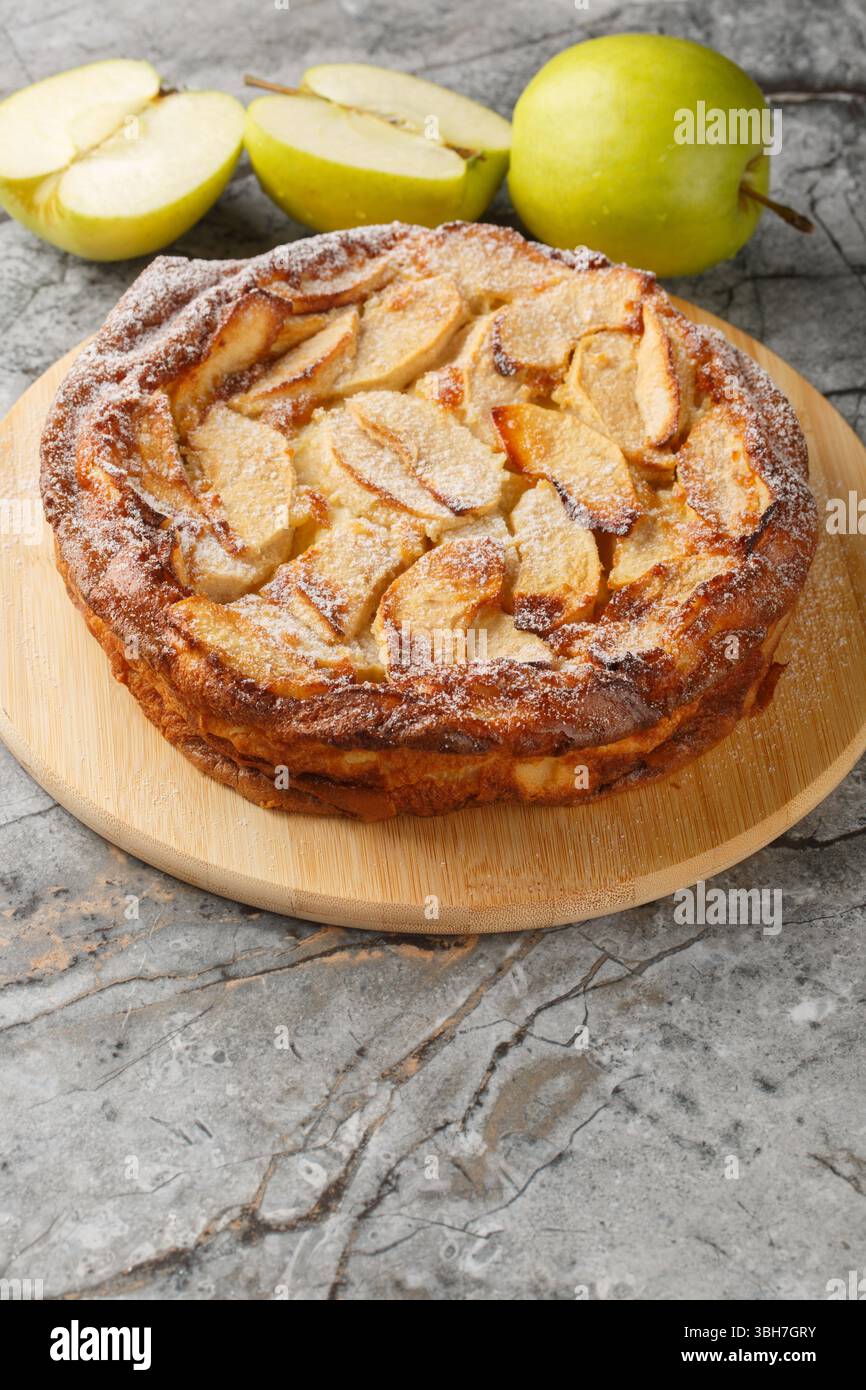 Tarte au clafoutis aux pommes française avec gros plan praliné sur une table. vertical Banque D'Images