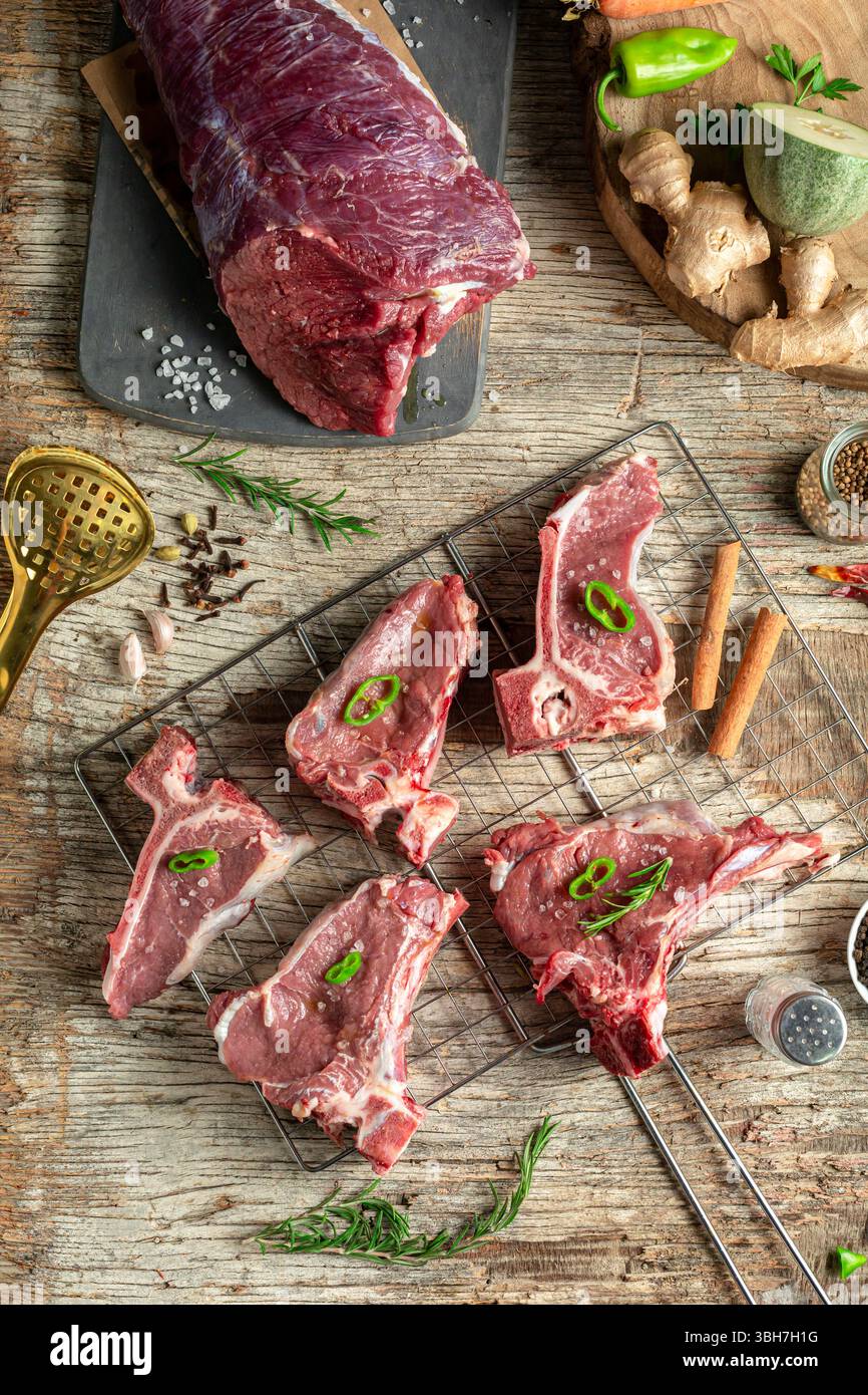Morceaux de viande d'agneau crue sur la surface en bois, vue de dessus. Banque D'Images