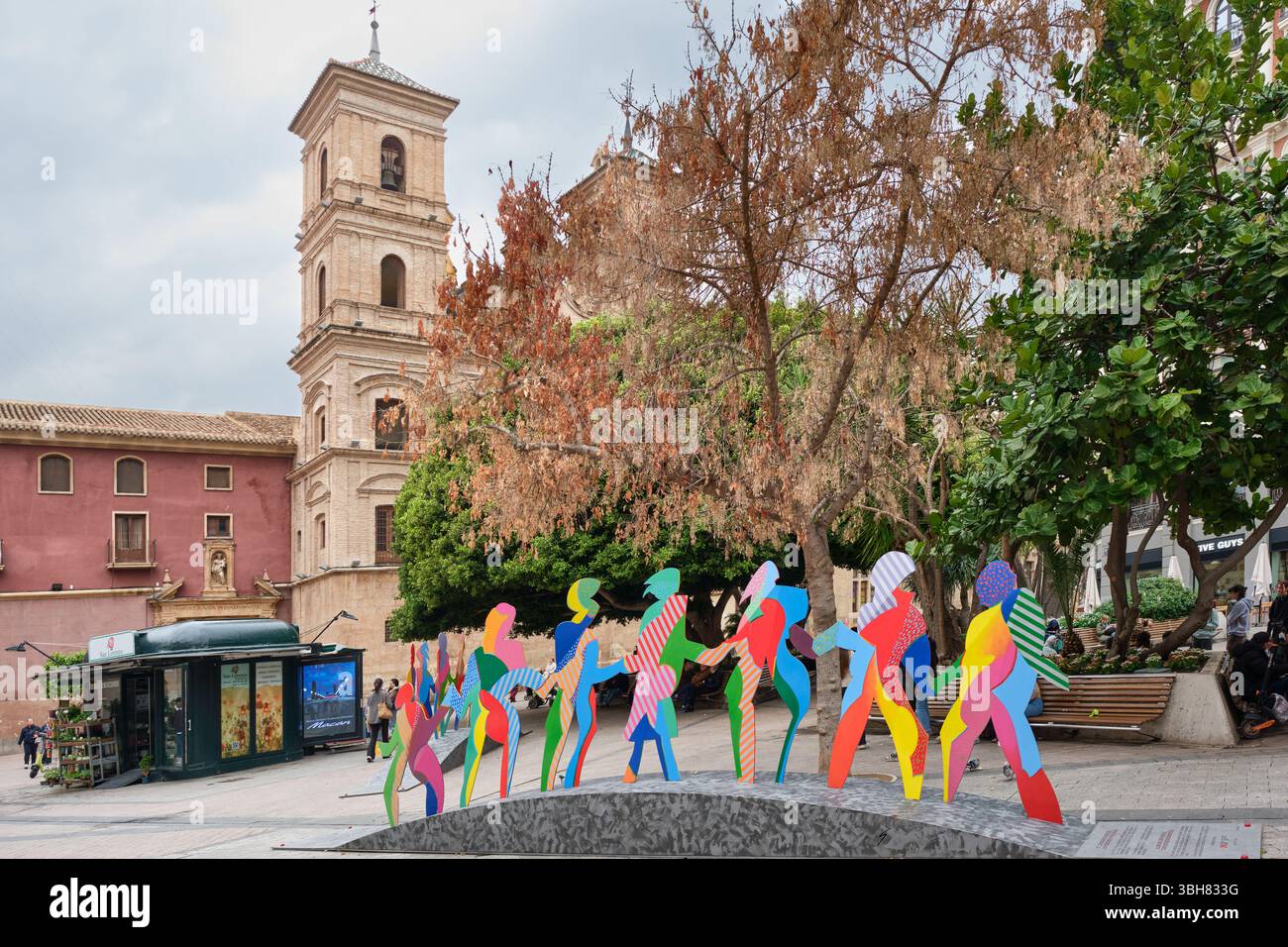 Sculptures colorées de personnes sur la place Santo Doming avec l'église du même nom dans la Murcie historique, Espagne Banque D'Images