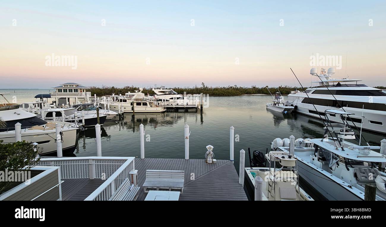 Boca Grande Marina, île Gasparilla, Floride. Des chalutiers, des bateaux de pêche et un Mega Yacht sont amarrés à la marina dans la lumière de début de soirée. Banque D'Images