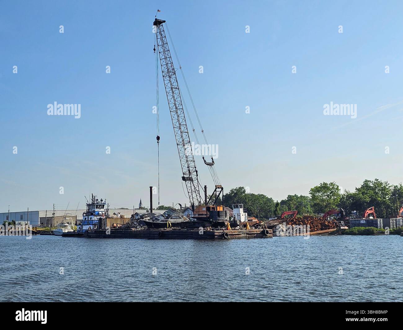 Barge collectant des bateaux abandonnés et d'autres débris, Brunswick. Les bateaux abandonnés et abandonnés sont un problème pour de nombreuses communautés riveraines en Amérique. - Image de stock capturée avec un smartphone