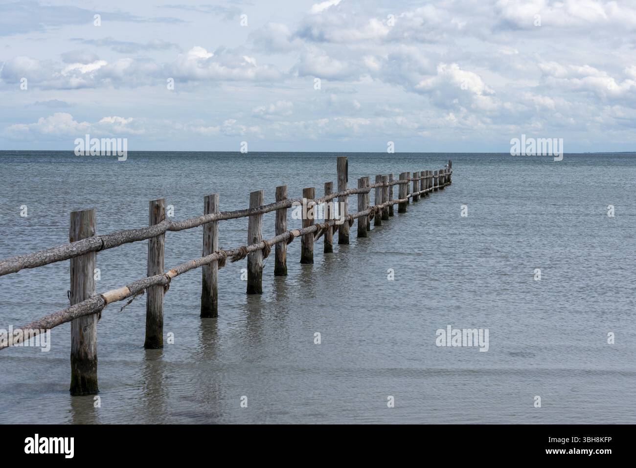 Longue jetée en bois se jette dans la mer calme avec un ciel nuageux à l'horizon, Prerow, Mecklembourg-Poméranie occidentale, Allemagne, Europe Banque D'Images
