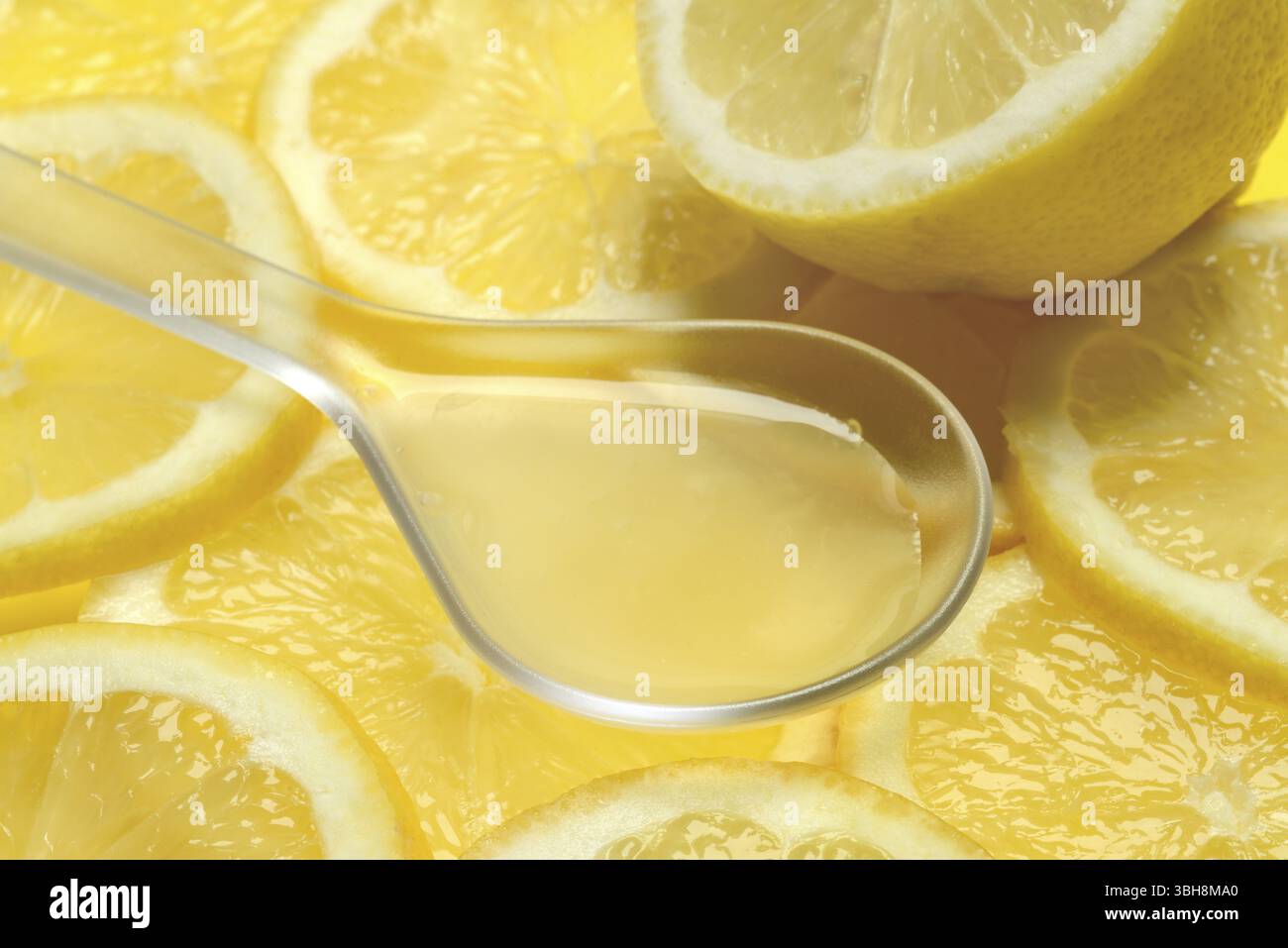 Jus de citron en louche et tranches de citron, Citrus x limon Banque D'Images