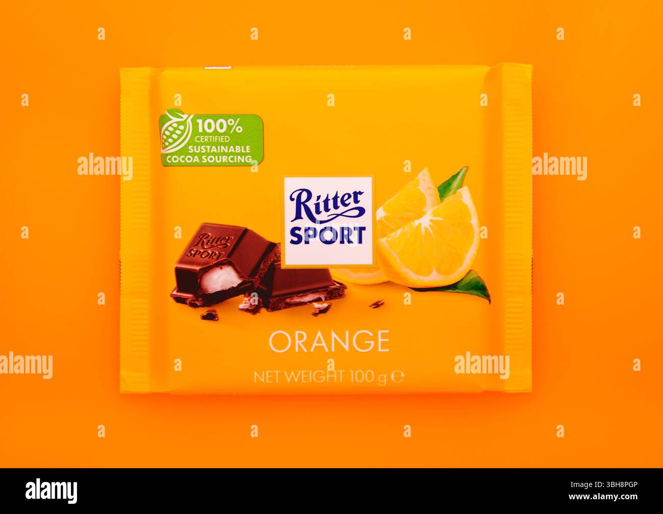 LONDRES, Royaume-Uni - 23 janvier 2025 : barre de chocolat Ritter Sport avec saveur de yaourt aux fruits à l'orange sur fond orange. Banque D'Images