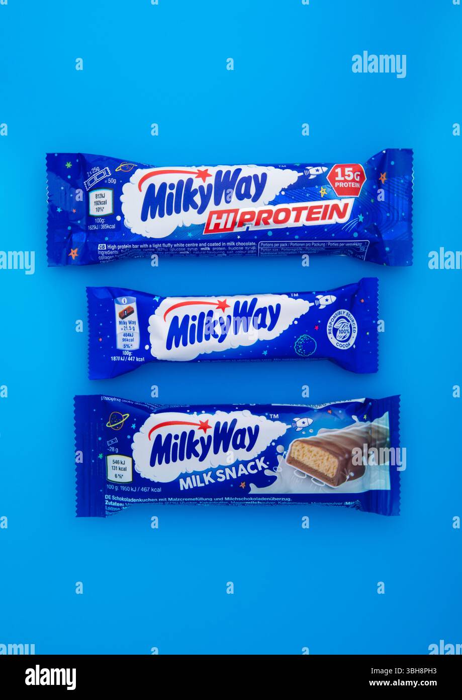 LONDRES, Royaume-Uni - 15 JANVIER 2025 : diverses barres de chocolat au lait et de nougat de la voie lactée sur fond bleu. Banque D'Images