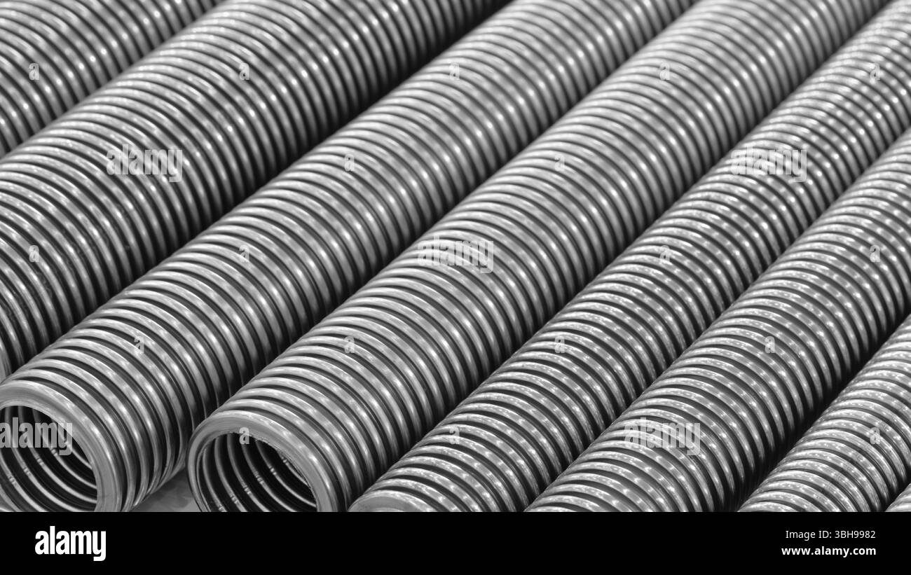 Rangée de tuyaux à haute pression ondulés en acier inoxydable de couleur argentée. Les tuyaux sont longs et minces. Fond de concept industriel mécanique Banque D'Images