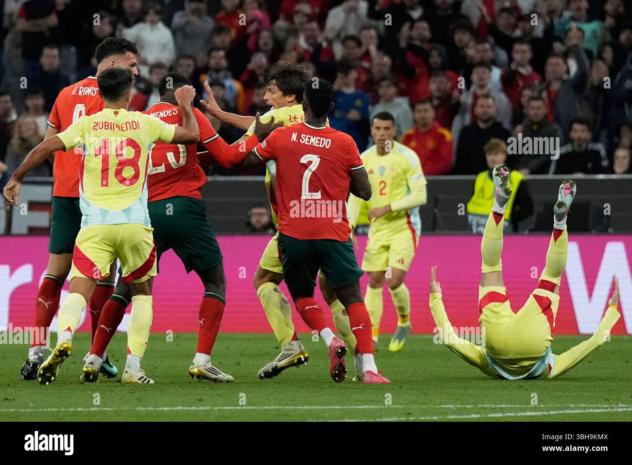 Spain's Alex Baena, right, falls on the pitch during the Nations League final soccer match between Portugal and Spain at the Allianz Arena in Munich, Germany, Sunday, June 8, 2025. (AP Photo/Matthias Schrader) Banque D'Images