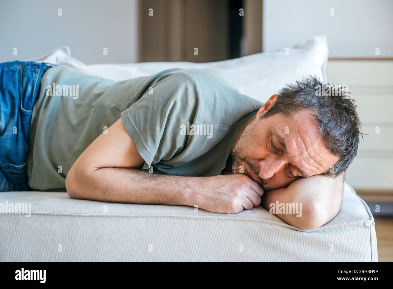 Homme triste désespéré allongé sur le canapé, se sentant misérable et déprimé, mise au point sélective Banque D'Images