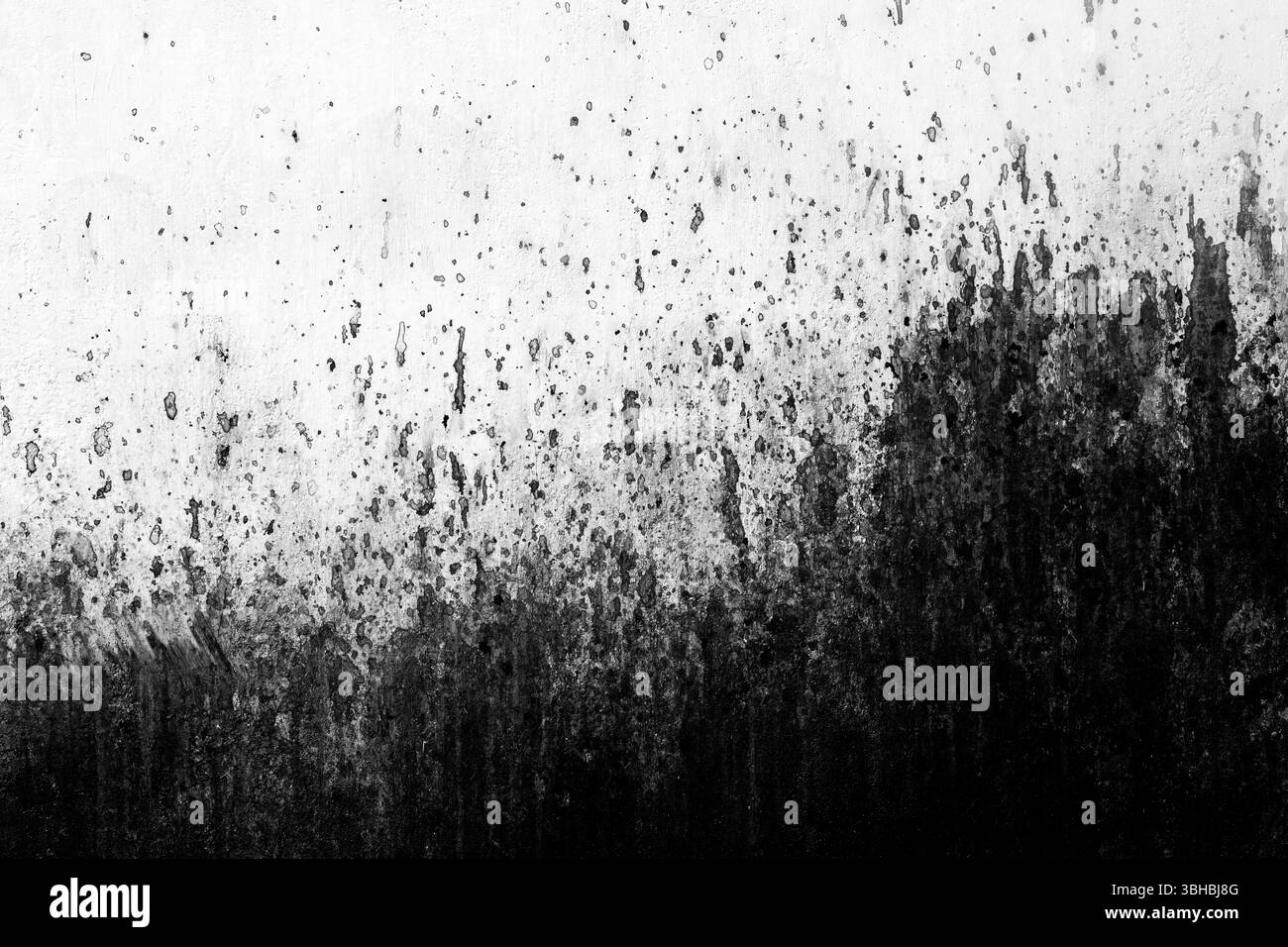 Peinture noire éclaboussure sur la surface blanche du mur comme arrière-plan et motif urbain Banque D'Images