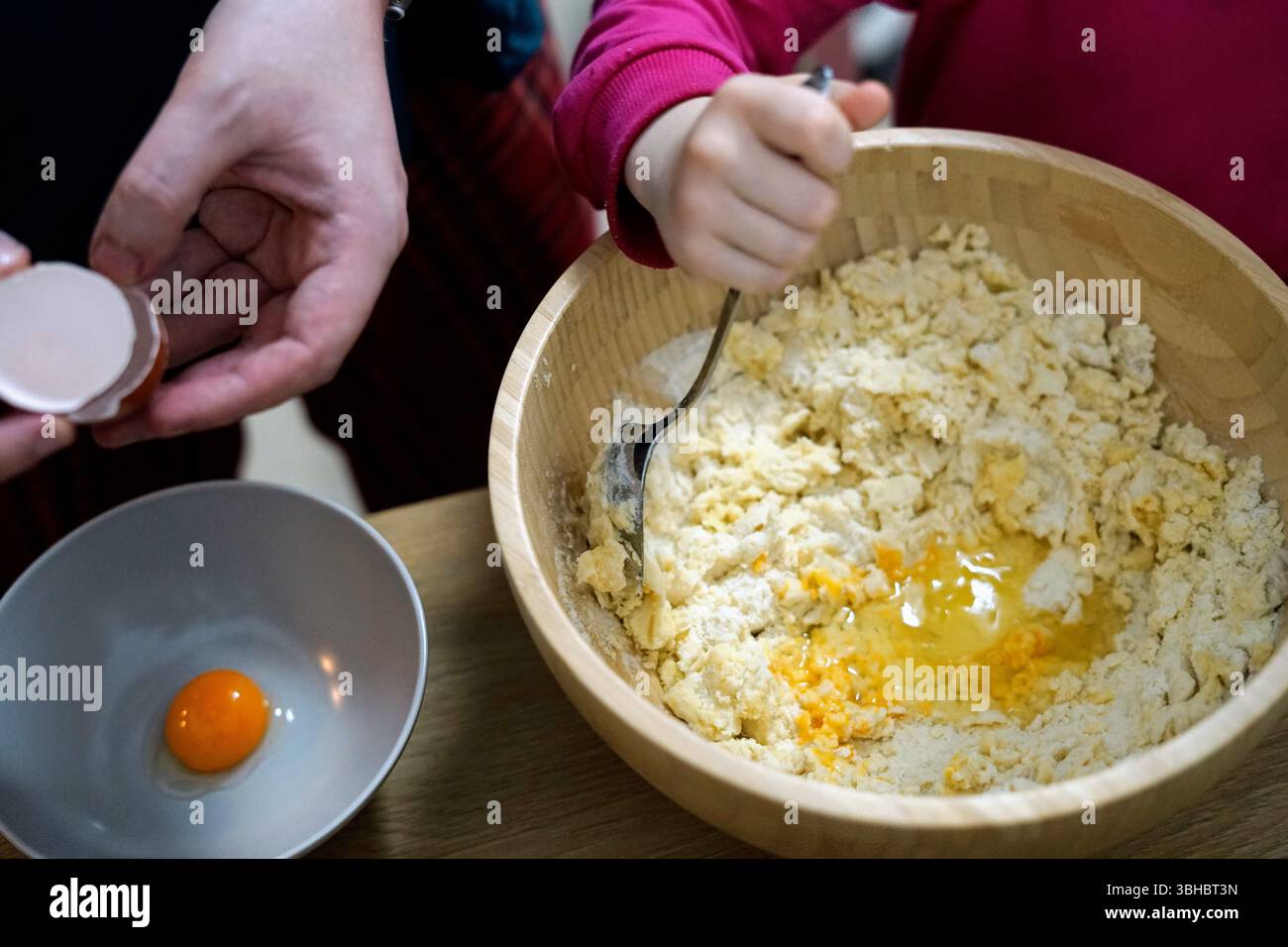 petite fille aider le père parent et la fille cuisiner gâteau pâtisserie remuer la famille ensemble cozy temps à la maison atmosphère authentique Banque D'Images