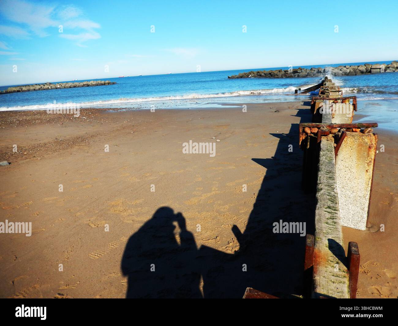 Ocean Shoreline avec Rusty Pier et Blue Sky un jour ensoleillé. Aberdeen, Écosse Banque D'Images