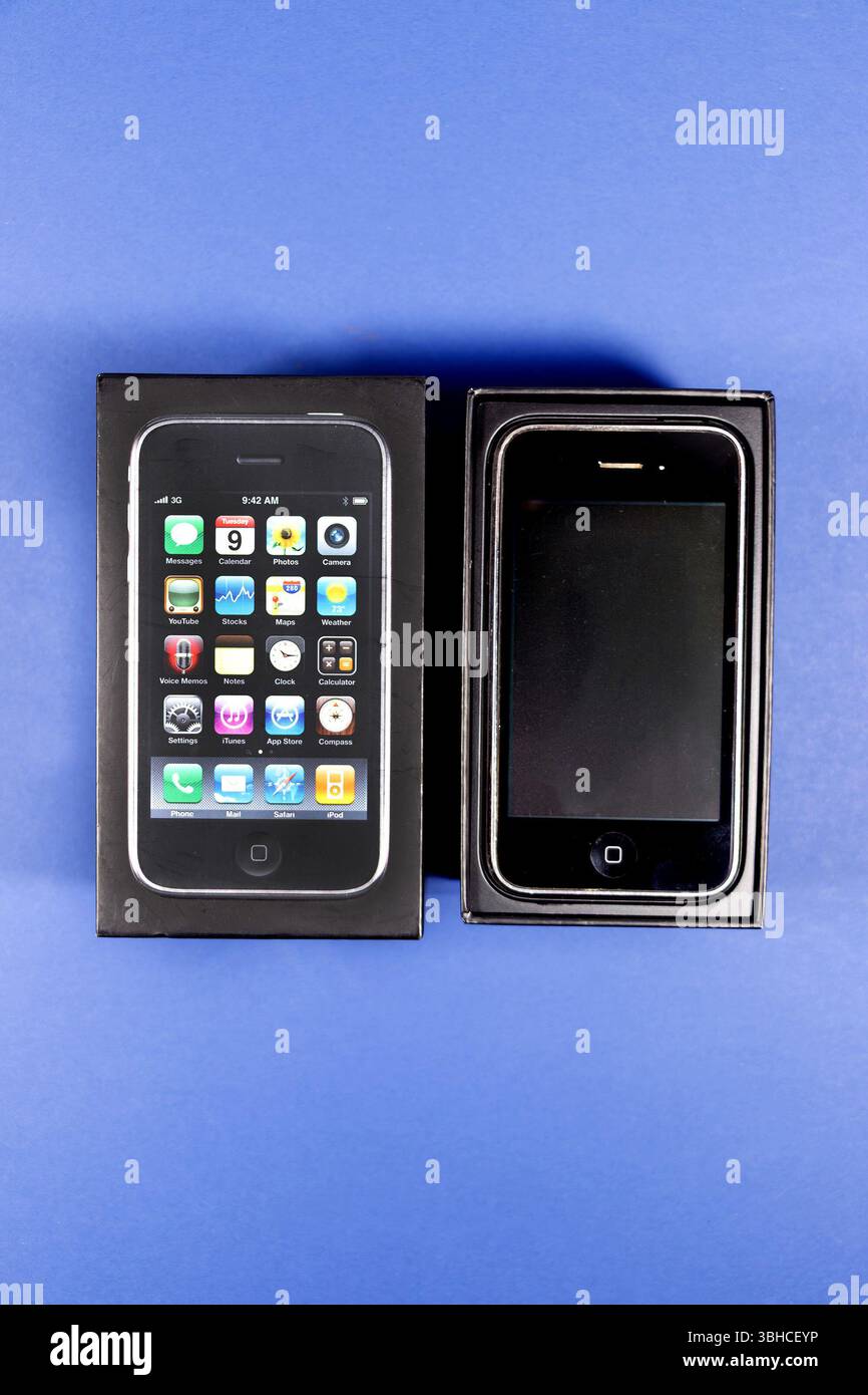 Un smartphone iphone 3GS original dans sa boîte à côté de l'emballage ouvert sur un fond bleu vif. Banque D'Images