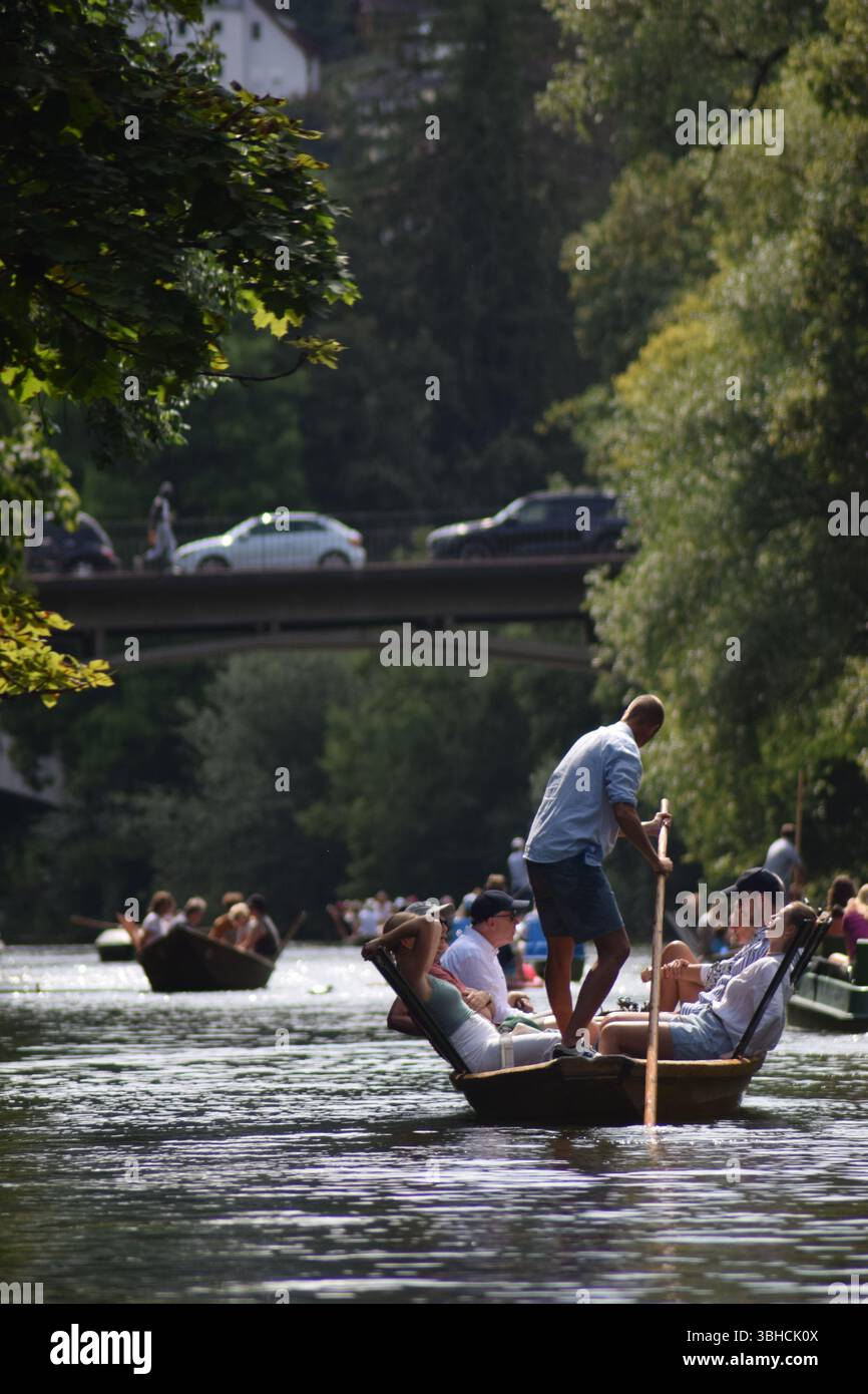 Les gens traversent la rivière Neckar à Tübingen, en Allemagne, sur de petits bateaux "Stocherkahn" Banque D'Images