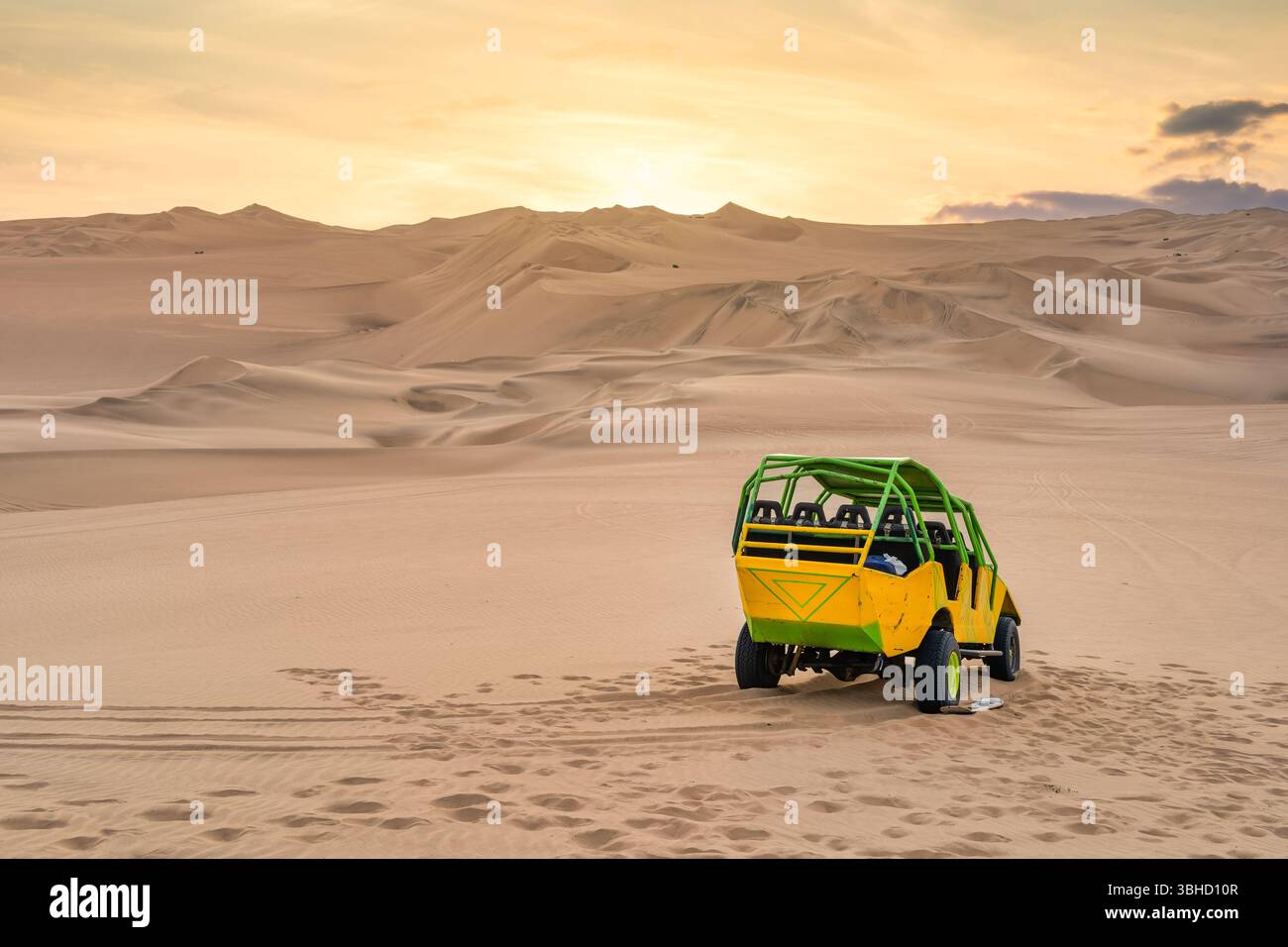 Un buggy de dune coloré sur les dunes de sable doré du désert d'ICA près de Huacachina, Pérou au coucher du soleil. Banque D'Images