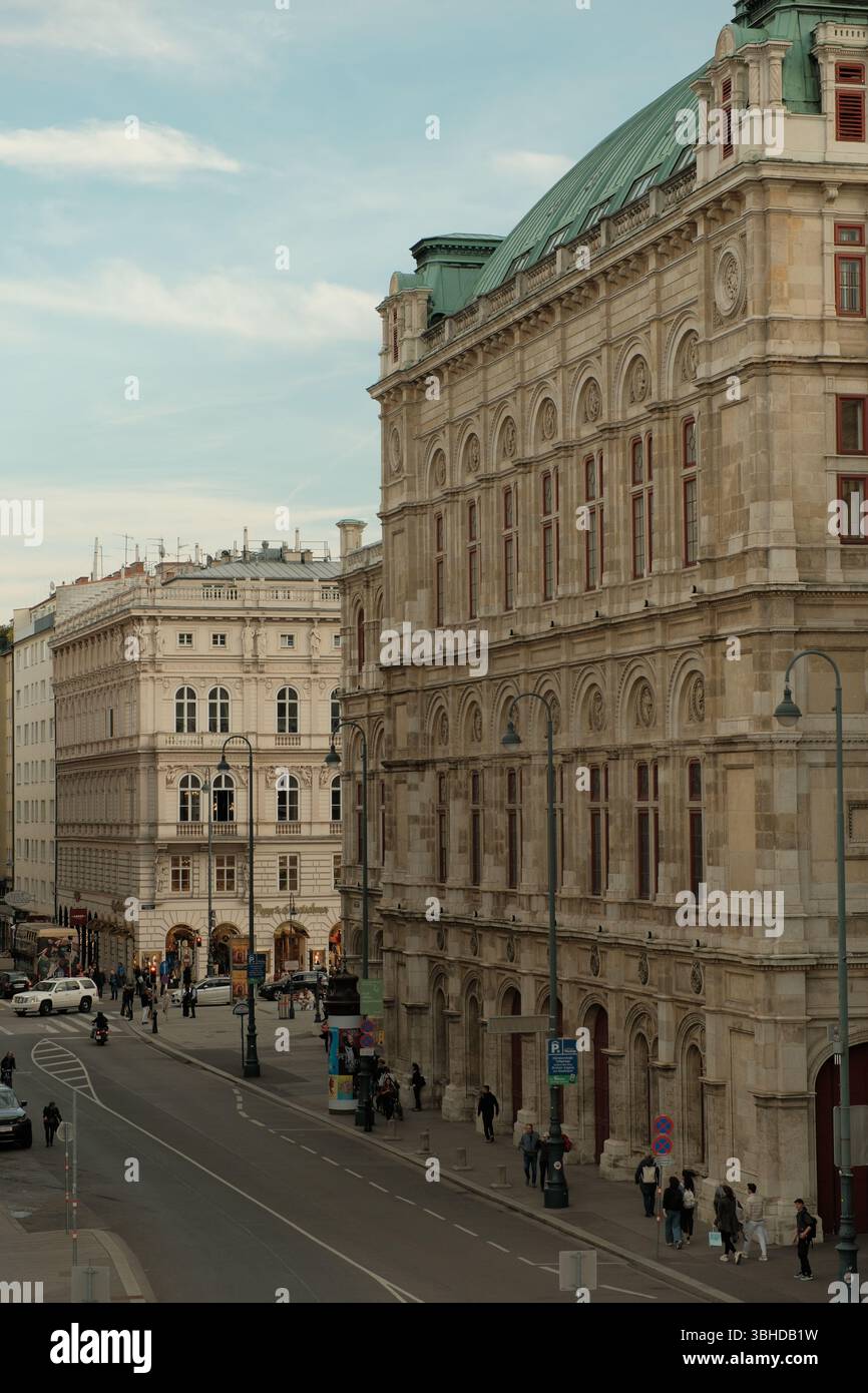 Vue sur la rue de l'Opéra national de Vienne avec son architecture néo-Renaissance grandiose et son toit en cuivre vert. Banque D'Images