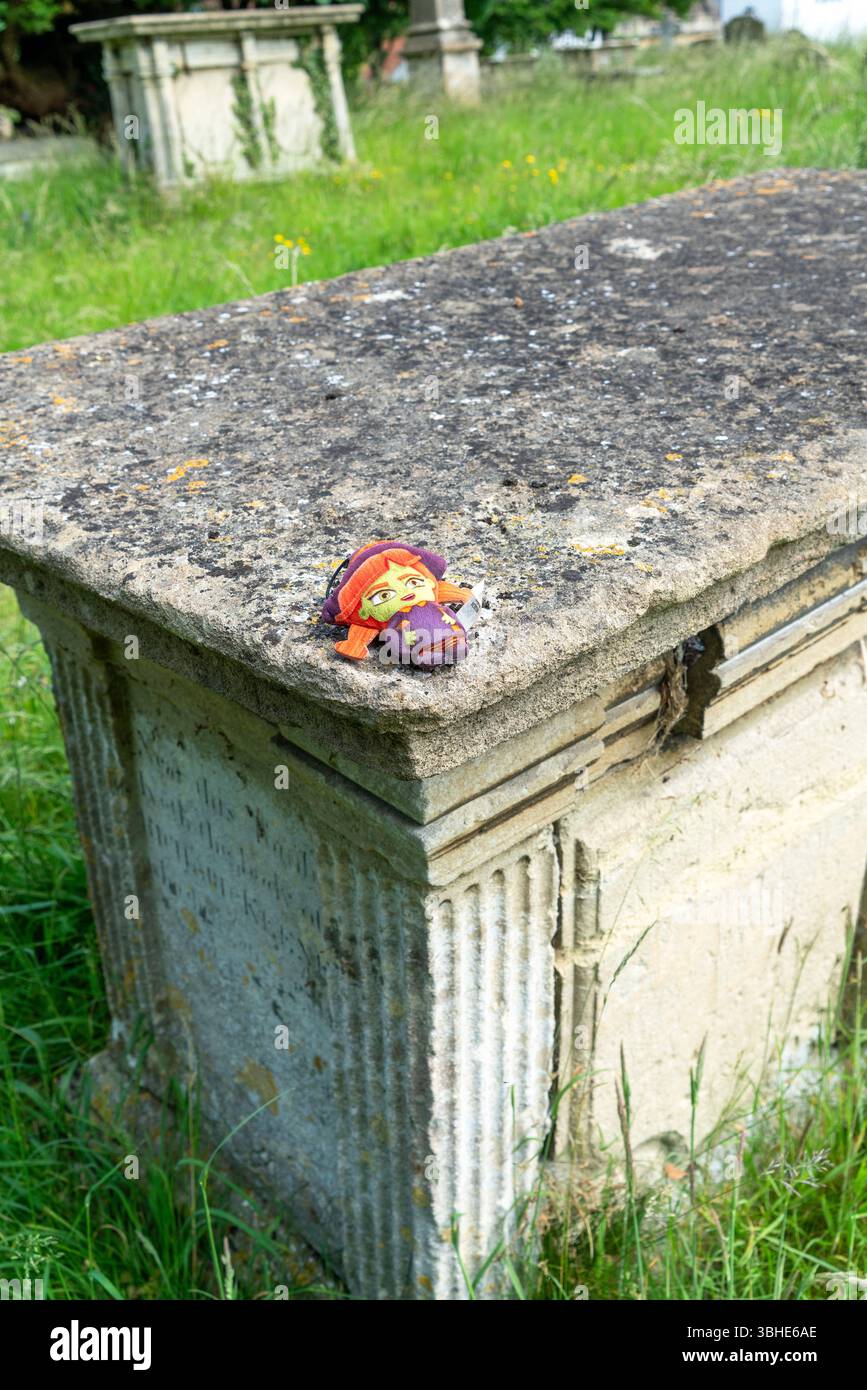 Petite peluche pour enfants laissée sur le dessus d'une pierre tombale Banque D'Images